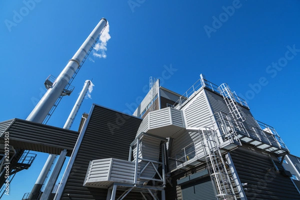 Obraz Boiler chimneys on a blue sky background