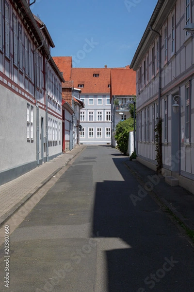 Fototapeta View into a little street with frame work houses in a city in germany on a sunny day