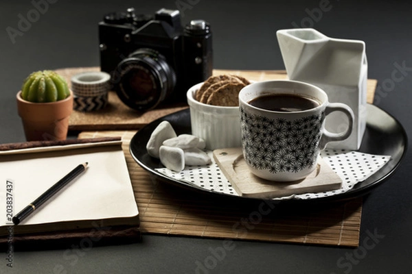 Fototapeta BlaTable set with coffee,  camera and note pad with empty space fot writing