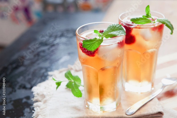 Fototapeta Refreshing summer drink with raspberry, mint and ice copy space