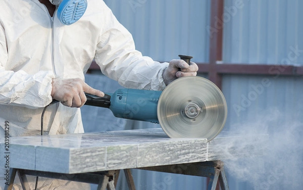 Obraz Worker cuts stone grinding machine