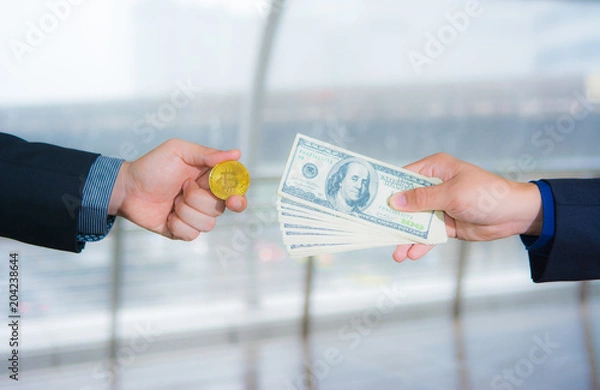 Fototapeta Two business men are exchanging between bitcoin and banknotes for financial concept between electronic and current currency