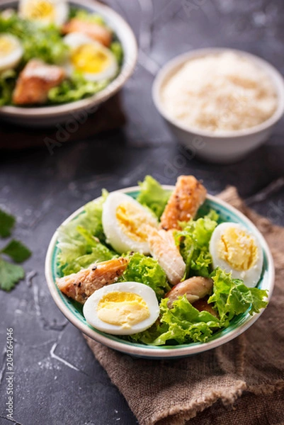 Fototapeta Caesar salad with eggs, chicken and parmesan