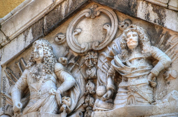 Fototapeta Closeup of Baroque era high reliefs of two long-haired men wearing plate armours on facade of Gradski toranj city clock tower a landmark building on main street Korzo in Rijeka Croatia Balkans Europe
