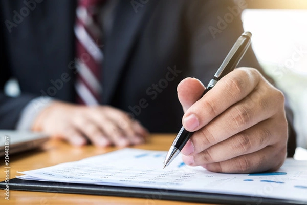 Fototapeta Professional businessman working, Doing finance on laptop, document graph and analysis business strategy to development profit