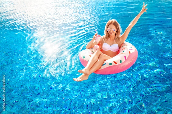 Fototapeta Letnie wakacje. Kobieta w bikini na dmuchanym materacu w pączku w basenie SPA. Podróż do koncepcji odpoczynku morza.