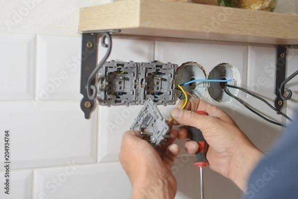 Fototapeta Electrician installing wall socket in new building