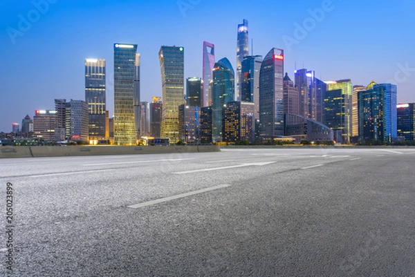 Fototapeta The empty asphalt road is built along modern commercial buildings in China's cities.