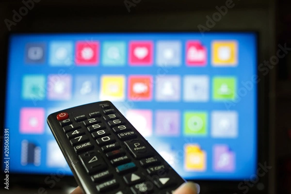 Fototapeta Watching TV and using remote controller