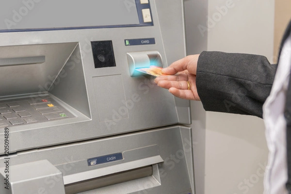 Obraz Woman hand used ATM card or credit card for withdraw money from ATM machine.