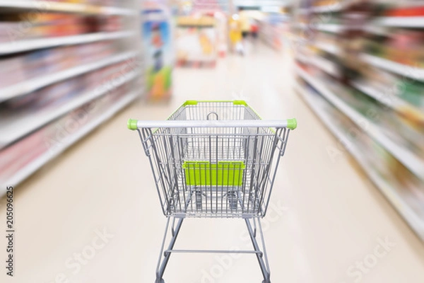 Fototapeta shopping cart with abstract motion blur supermarket discount store aisle and product shelves interior defocused background
