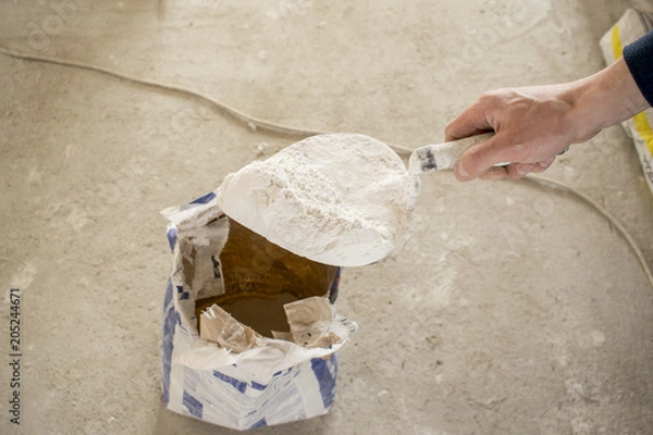 Fototapeta typed powder from the bag trowel for the preparation of plaster