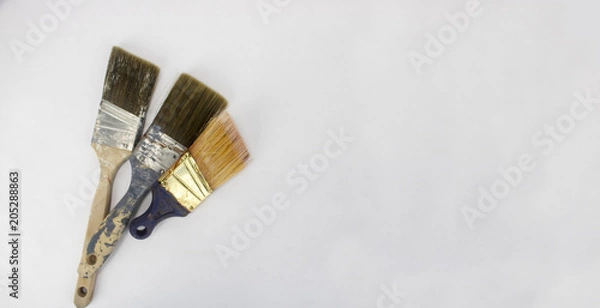 Obraz Three used paintbrushes on an isolated white background with room for text and other objects