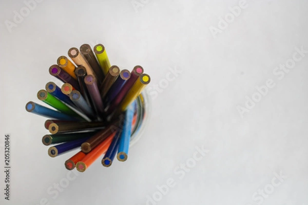 Obraz A jar of colored pencils on an isolated white background with room for text viewed from above