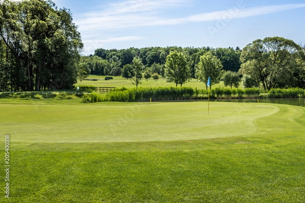 Fototapeta Golfplatz mit blauer Flagge