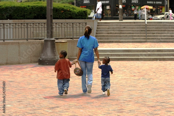 Fototapeta mother and two childeren walking holding hands