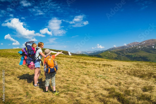 Fototapeta Family of hikers on a trekking day in a valley