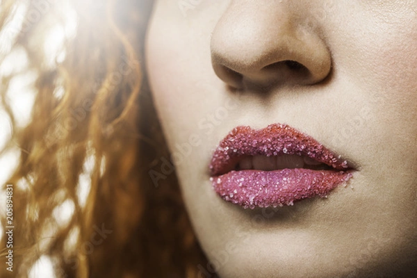 Fototapeta Close up of a woman's lips with pink lipstick and sugar