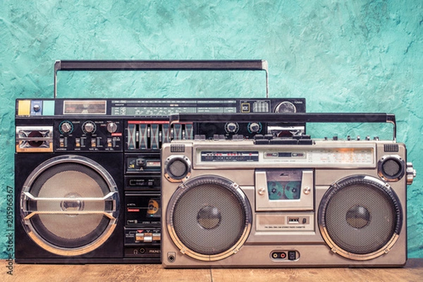 Fototapeta Retro zaprojektowane odbiorniki radiowe typu boombox z ghetto blaster stereo z magnetofonami kasetowymi z około lat 80-tych z teksturą na ścianie w kolorze akwamaryny. Koncepcja muzyki słuchania. Zdjęcie filtrowane w starym stylu vintage