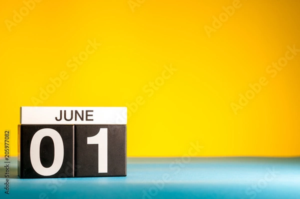 Fototapeta June 1st. Day 1 of june month, calendar on table with yellow background. Summer time, empty space for text