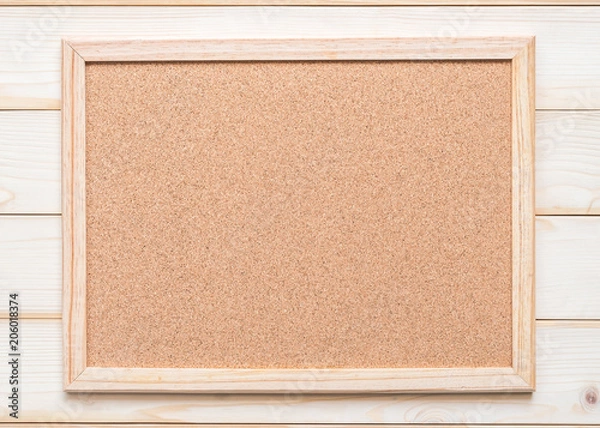 Fototapeta Blank cork board with corkboard texture with wooden frame hanging on white wood wall background