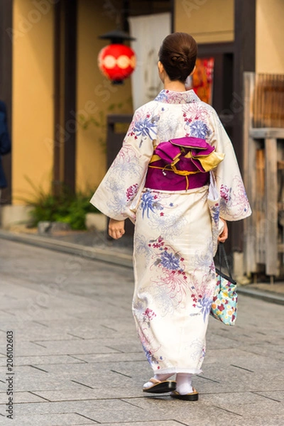 Fototapeta Girl in a kimono on a city street, Kyoto, Japan. Vertical. Copy space for text.