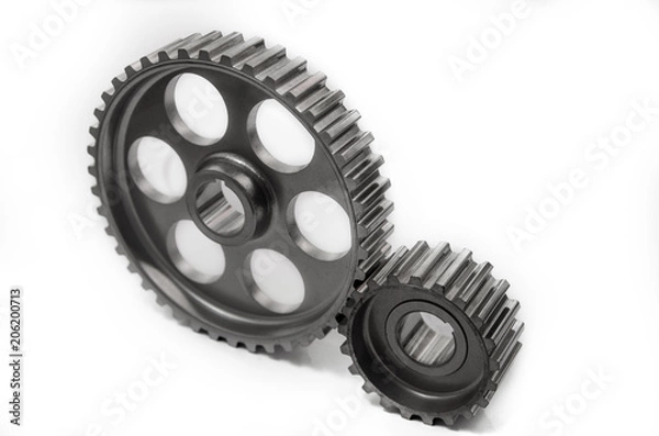 Fototapeta A gear wheel or pinion is a basic part of a gear train in the form of a disc with teeth on a cylindrical or conical surface meshing with the teeth of another gear