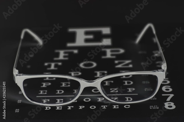 Fototapeta Eyeglasses on eyesight test chart background.