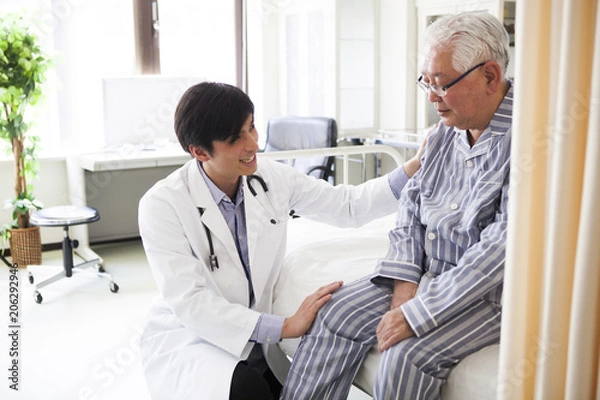 Fototapeta 医療用ベッドで医師の診断を受ける高齢者の男性。