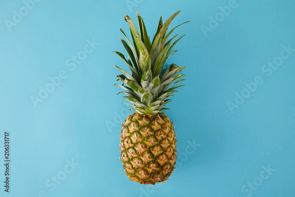 Obraz top view of ripe exotic pineapple fruit isolated on blue