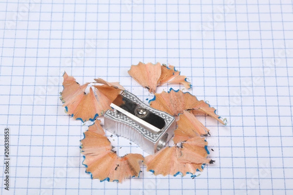 Fototapeta pencil shapener and pencil shaving on a squares sheet