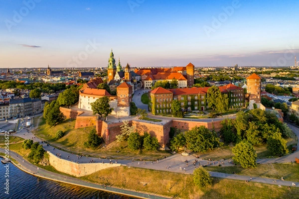 Obraz Polska. Panoramę Krakowa ze Wzgórzem Wawelskim, Katedrą, Zamkiem Królewskim na Wawelu, murami obronnymi, brzegiem Wisły, parkiem, promenadą, spacerującymi ludźmi. Stare miasto w tle