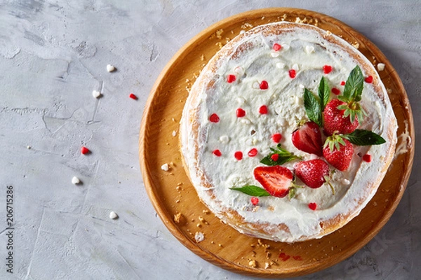 Fototapeta Tart with strawberries and whipped cream decorated with mint leaves on white textured background, selective focus
