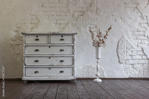 Fototapeta Vintage chest of drawers in the background of the old wall. Vintage interior.
