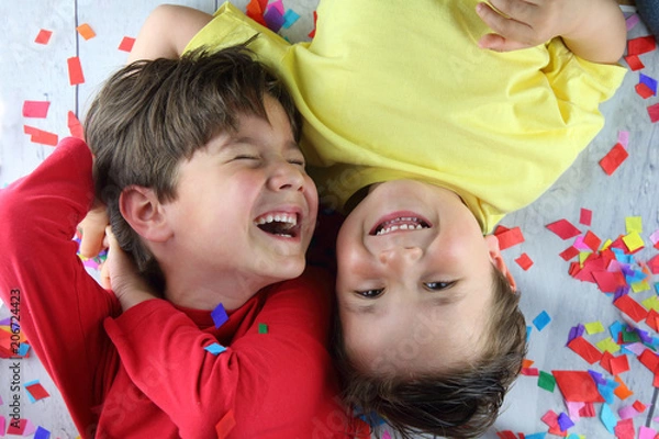 Fototapeta niños tumbados sobre confetti riendo en una fiesta de cumpleaños