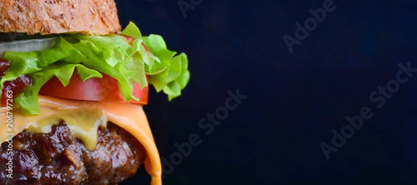 Obraz Burger flyer. Cheese burger with grilled meat, cheese, tomato, salad and onion rings. Close-up of delicious fresh home made burger with salad and cheese on bark blue background