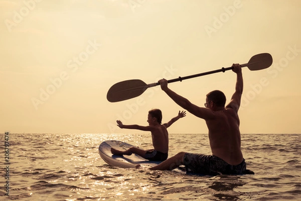 Obraz Ojciec i syn bawią się na plaży w ciągu dnia.