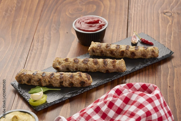 Obraz Grilled Veal minced meat with spices on black stone and wooden background 