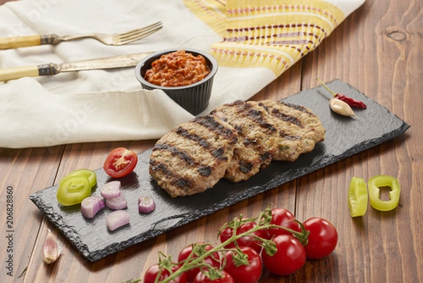 Obraz Grilled Veal minced meat with spices on black stone and wooden background 
