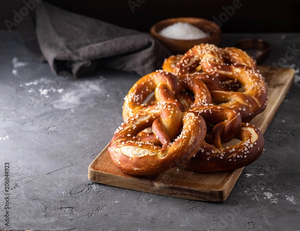 Fototapeta Freshly baked homemade soft pretzel with salt on rustic table. Perfect for Octoberfest. 