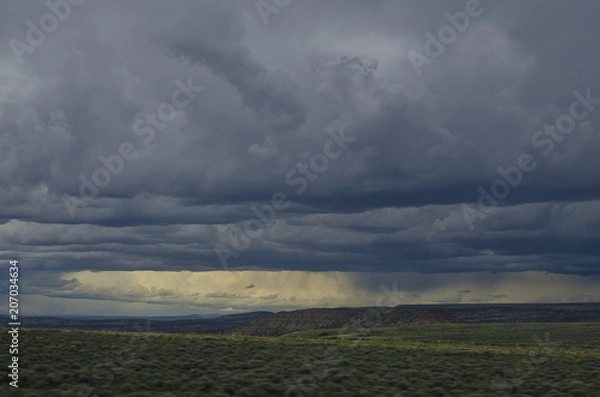Obraz The dark gloomy rain clouds over the desert open range on a spring evening. 