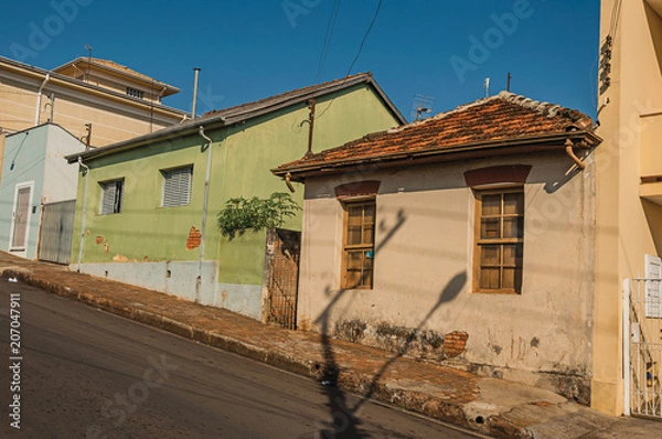 Fototapeta Working-class shabby colored houses in an empty street on a sunny day at São Manuel. A cute little town in the countryside of São Paulo State. Southeast Brazil.