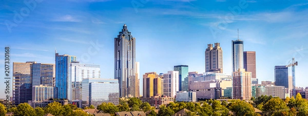 Fototapeta Downtown Atlanta Skyline przedstawiający kilka znanych budynków i hoteli pod błękitnym niebem.