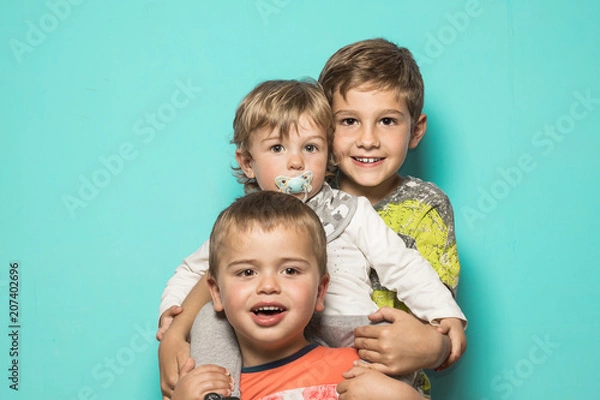 Obraz Three smiling children hugging each other