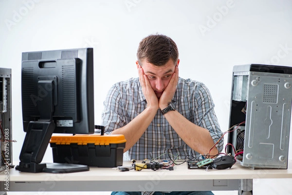 Fototapeta Young technician repairing computer in workshop