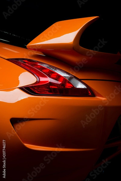 Fototapeta Car detailing series: Clean of rear orange sports car in the dark