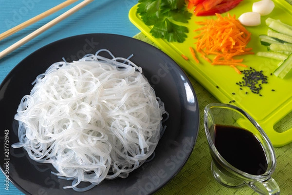Obraz cellophane noodles on a plate on a wooden table with vegetables salad cooking