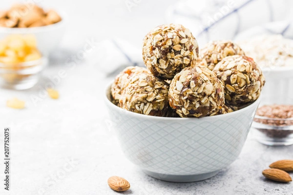 Fototapeta Vegan dessert, raw oatmeal nuts fruit bites. Selective focus, space for text.