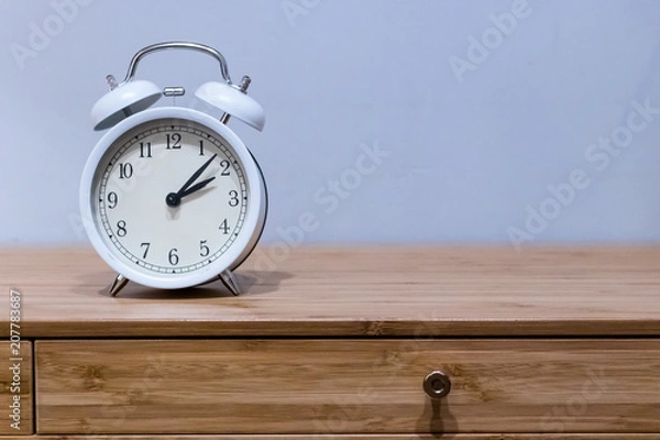Obraz White alarm clock on wooden desk