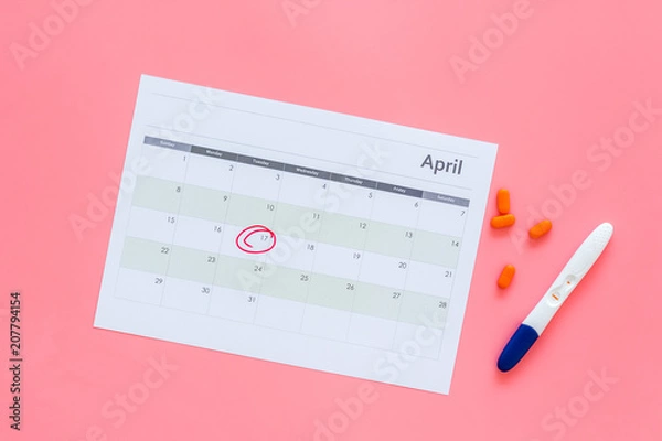 Fototapeta Planning pregnancy. Positive pregnancy test near calendar page and pills on pink background top view copy space